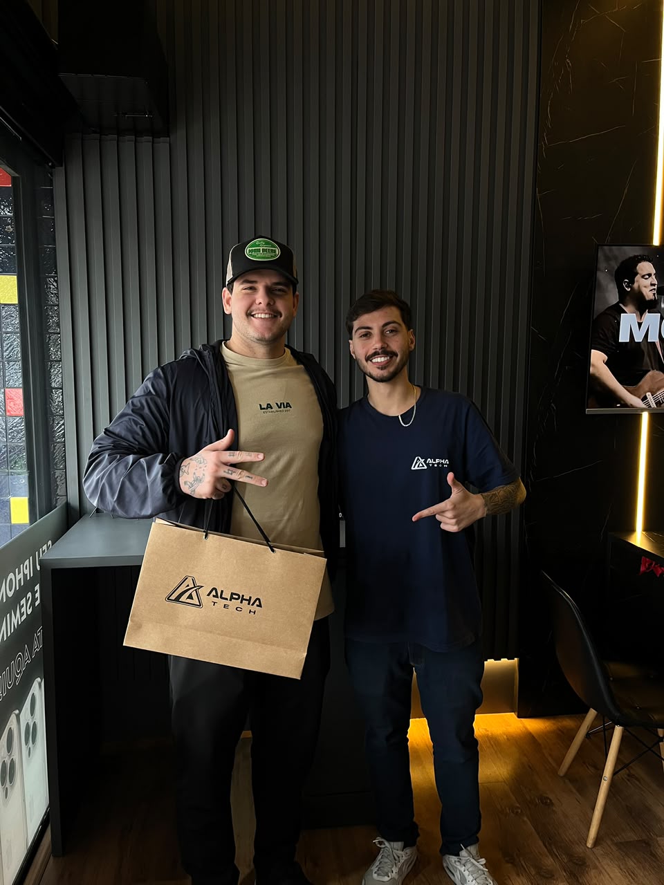 Cliente com a sacola da Alphatech ao lado do vendedor